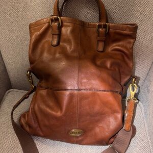 brown leather Fossil Explorer fold-over tote bag with a crossbody strap
